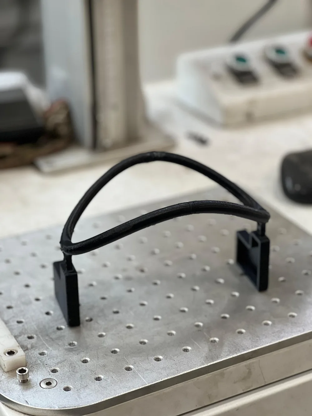 The 3D-printed headband, a black arched band with two electrode holders, on a lab bench